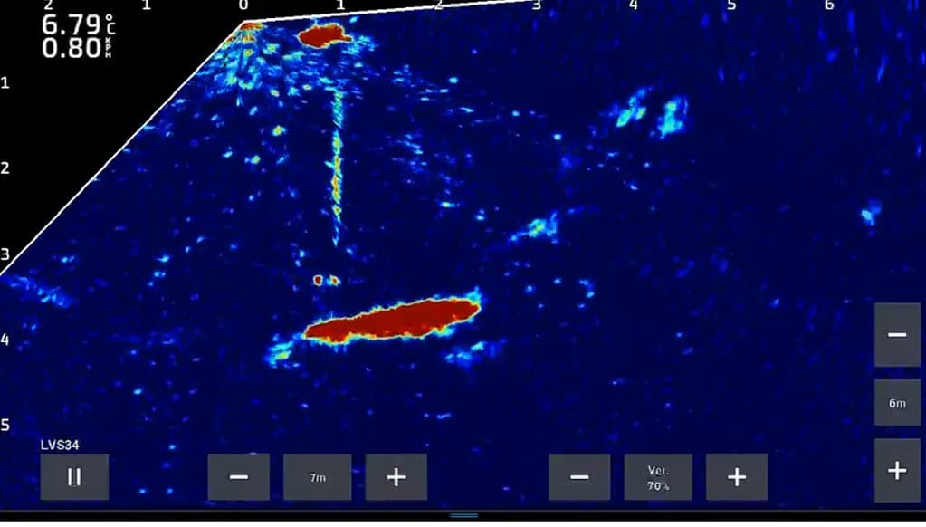 Sonardisplay met twee opvallende rode vormen tegen een blauwe achtergrond, met schaalindicatoren en bedieningsknoppen aan de onderkant.