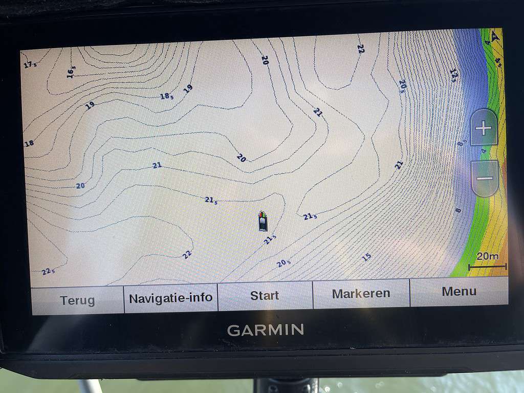 Het Garmin navigatieapparaat toont een kaart met hoogtelijnen en dieptegetallen, ideaal voor het verkennen van plassen tijdens de wintervisserij. Menuopties zijn handig onderaan het scherm geplaatst.