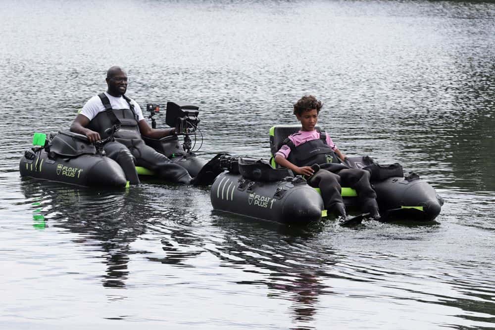 Twee mensen zitten in individuele opblaasbare waterscooters met aangesloten camera's, drijvend op een kalm water en leggen herinneringen vast tijdens Vistival 2024 – een groot succes.